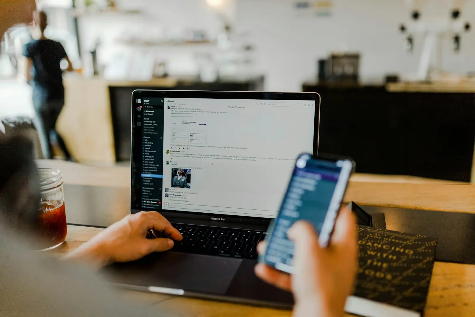 Marketer checking ad results on a laptop and a smartphone
