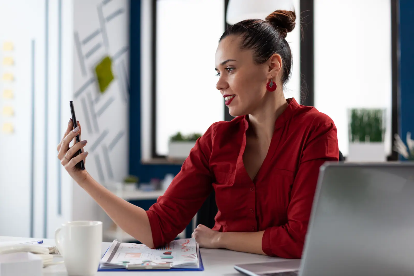 Social media manager filming content with a smartphone in the office